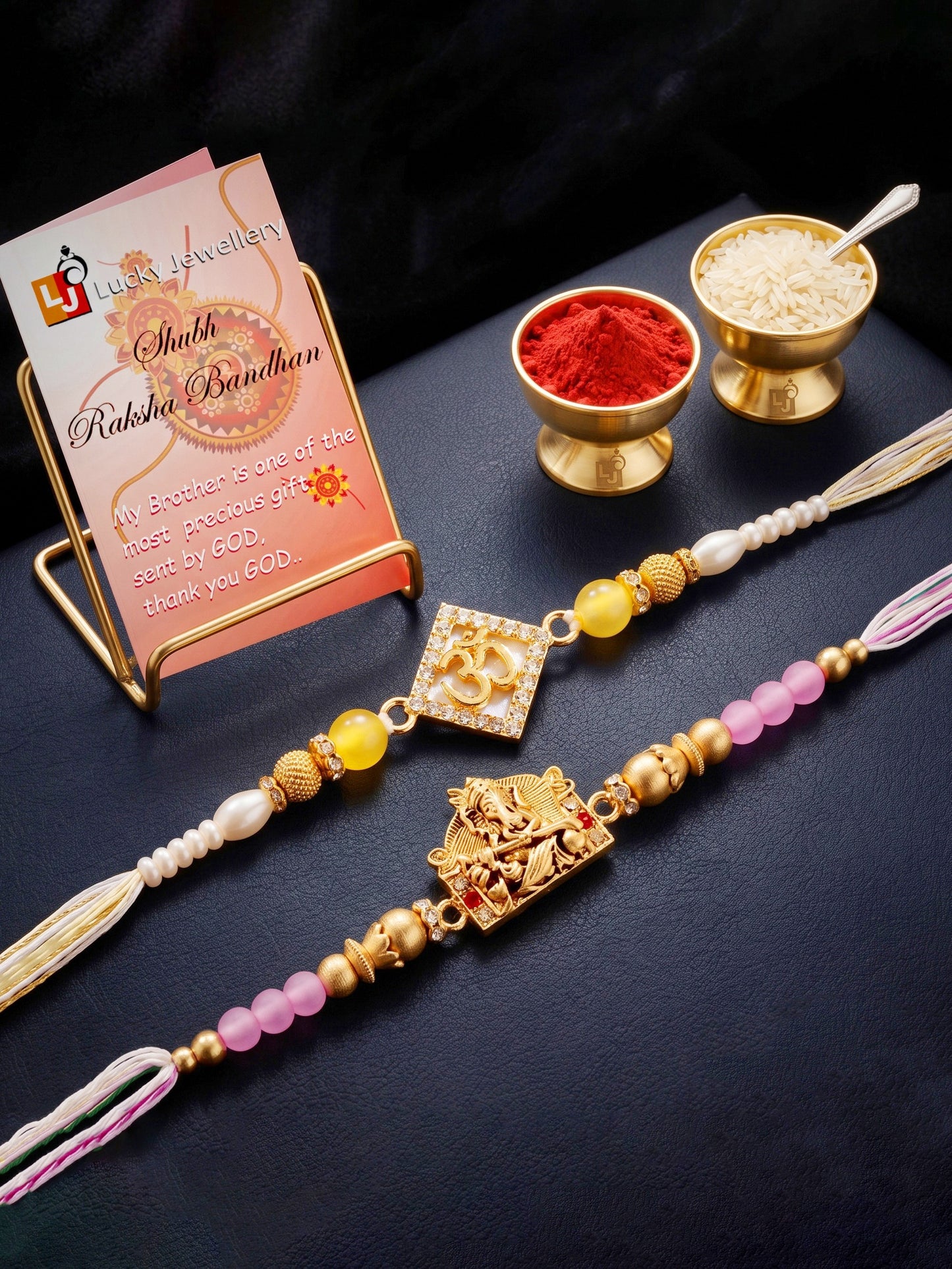 Lucky Jewellery Set of 2 Rakhi with Om & Ganesha Pendants, Pink & Smooth White Beads, Roli Chawal & Card (188-S7R1-2316-2)