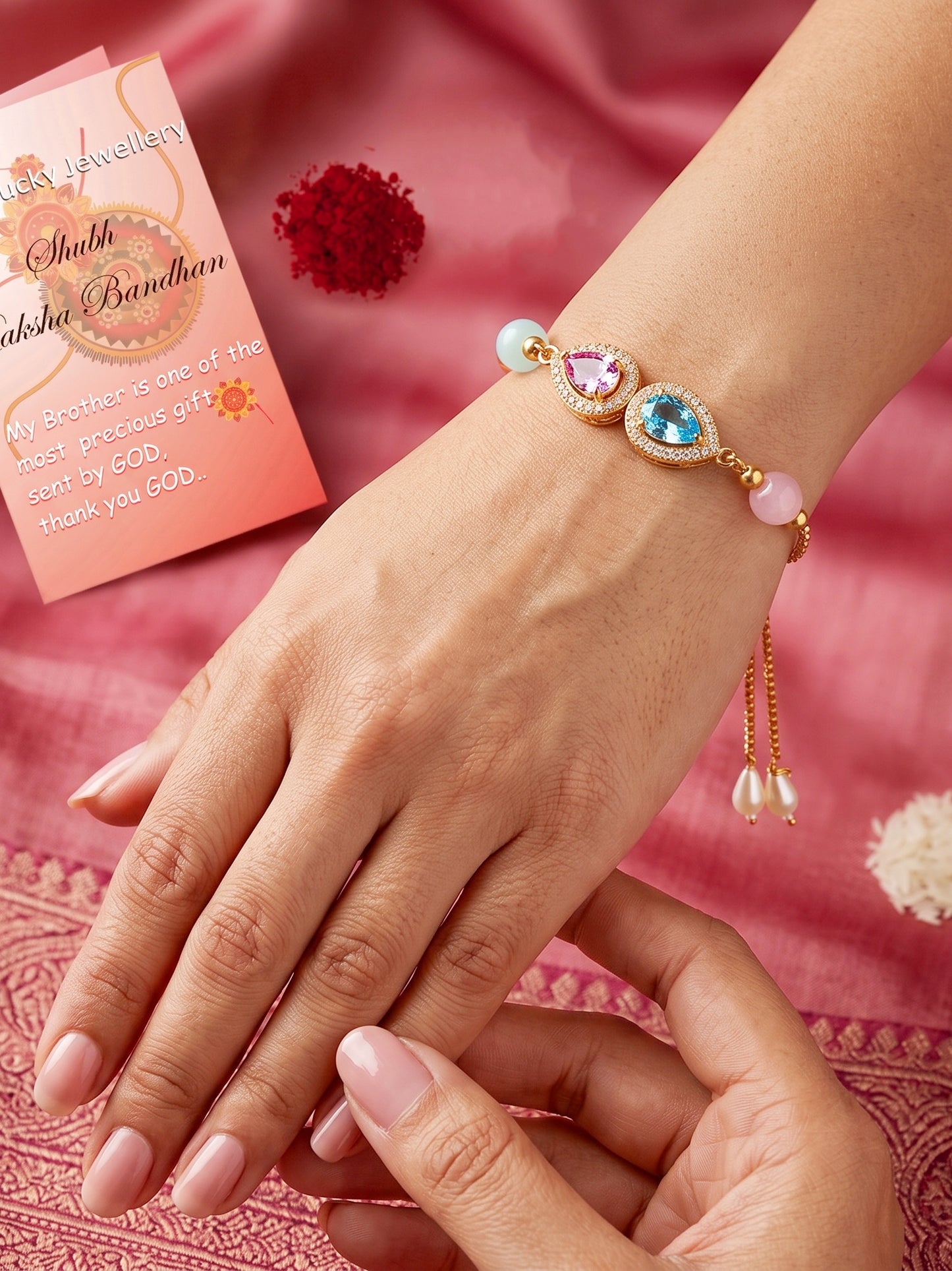 Adjustable Rakhi Bracelet with Blue & Pink drop AD Pendant,Pastel Beads,Roli Chawal & Card (209-CHB2-1279-PKF-2026)