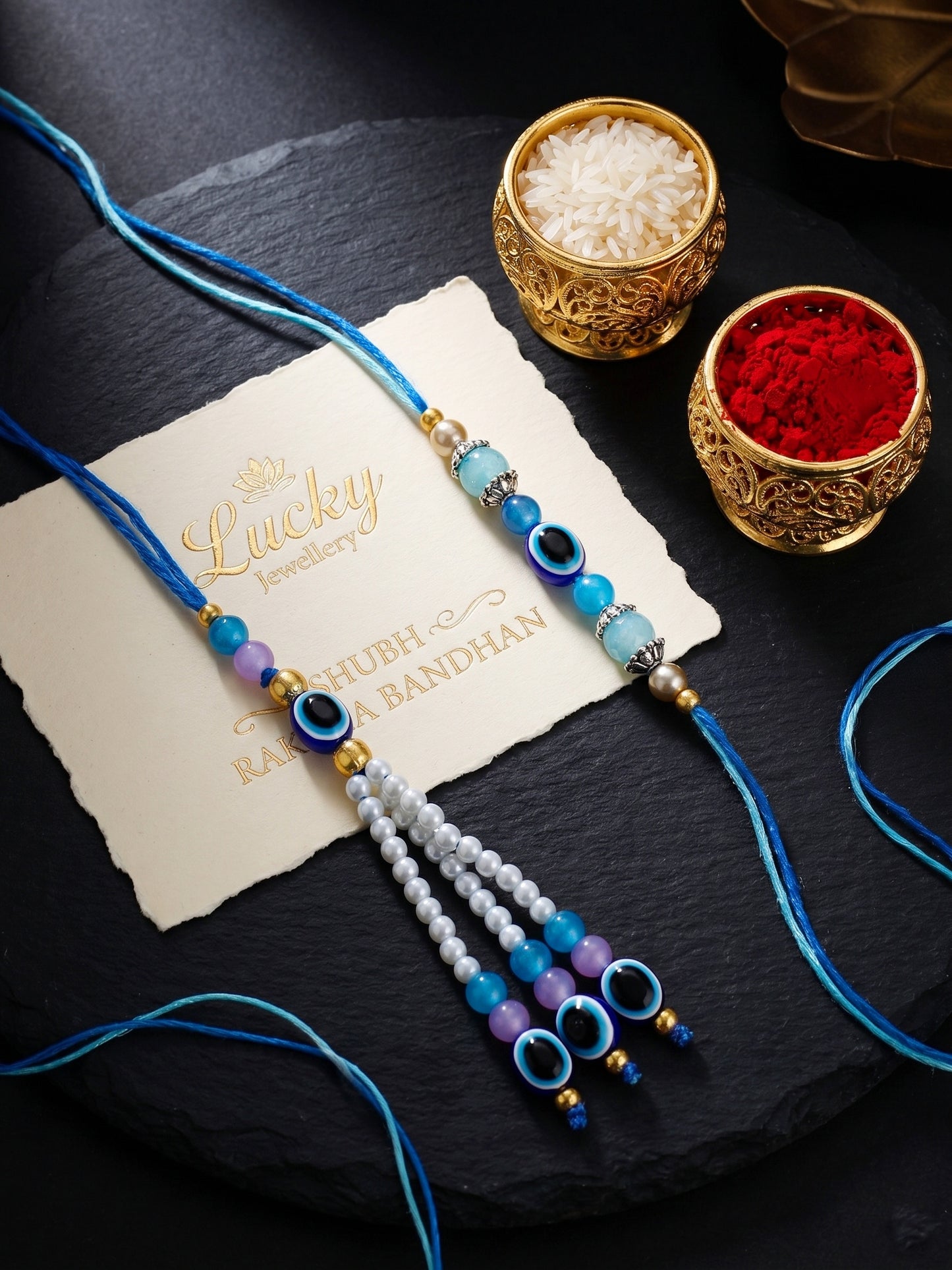 Set of 2 Bhaiya Bhabhi Evil Eye Rakhi Set with Blue & White Beads, Lumba Tassel, Roli Chawal & Card (75-J5R1-1993-EE-2-2026)