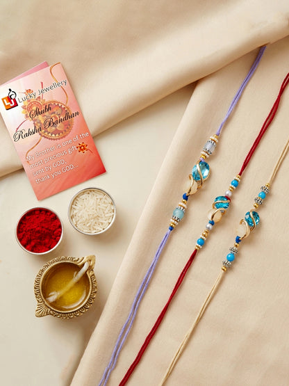 Designer Rakhi Set of 3: Blue Crystal, Cream Stone, Metallic Spacers, Roli, Chawal & Card (300-CHR1-1002A-3-2026)