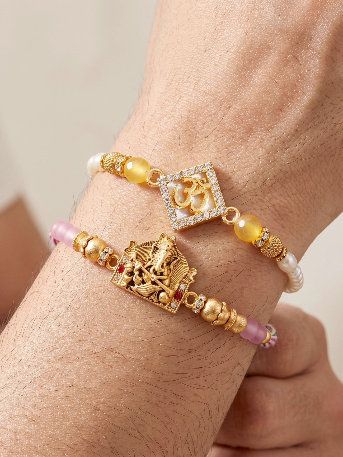 Lucky Jewellery Set of 2 Rakhi with Om & Ganesha Pendants, Pink & Smooth White Beads, Roli Chawal & Card (188-S7R1-2316-2)